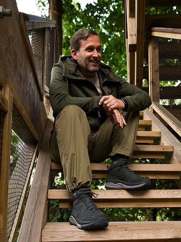 A male hiker sitting on wooden steps
